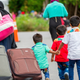 Asylum seekers walk along Roxham Road near Champlain, New York on August 6, 2017, making their way towards the Canada/US border.